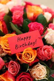 Image of Bouquet of beautiful roses with Happy Birthday card, closeup