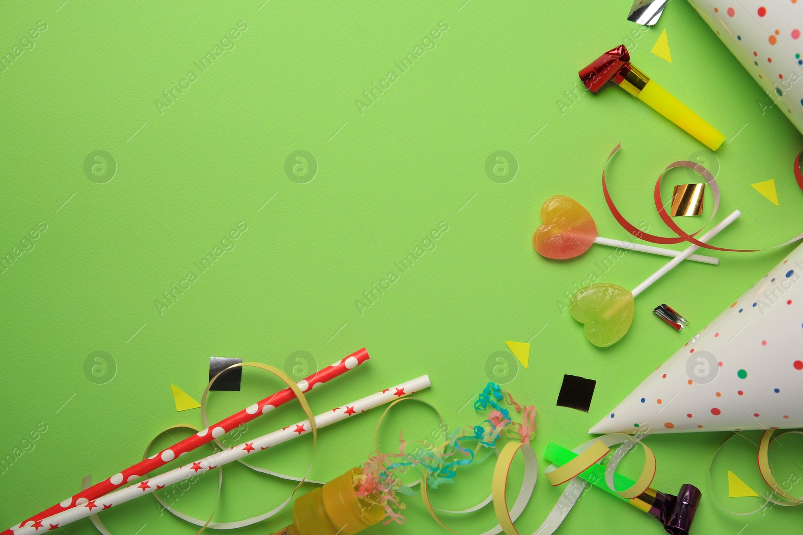 Photo of Colorful blowers, streamers and other festive decor on light green background, flat lay. Space for text