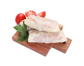 Photo of Wooden board with uncooked stuffed cabbage rolls, tomatoes and parsley isolated on white