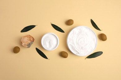 Photo of Natural cosmetic. Different olive creams, mineral and ingredient on beige background, flat lay