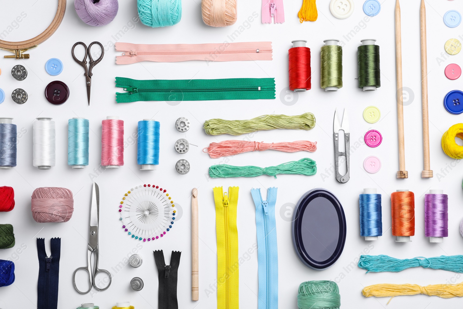 Photo of Composition with color threads and sewing accessories on white background, top view