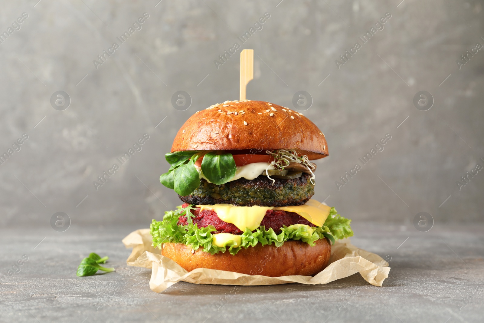 Photo of Vegan burger with beet and falafel patties on table