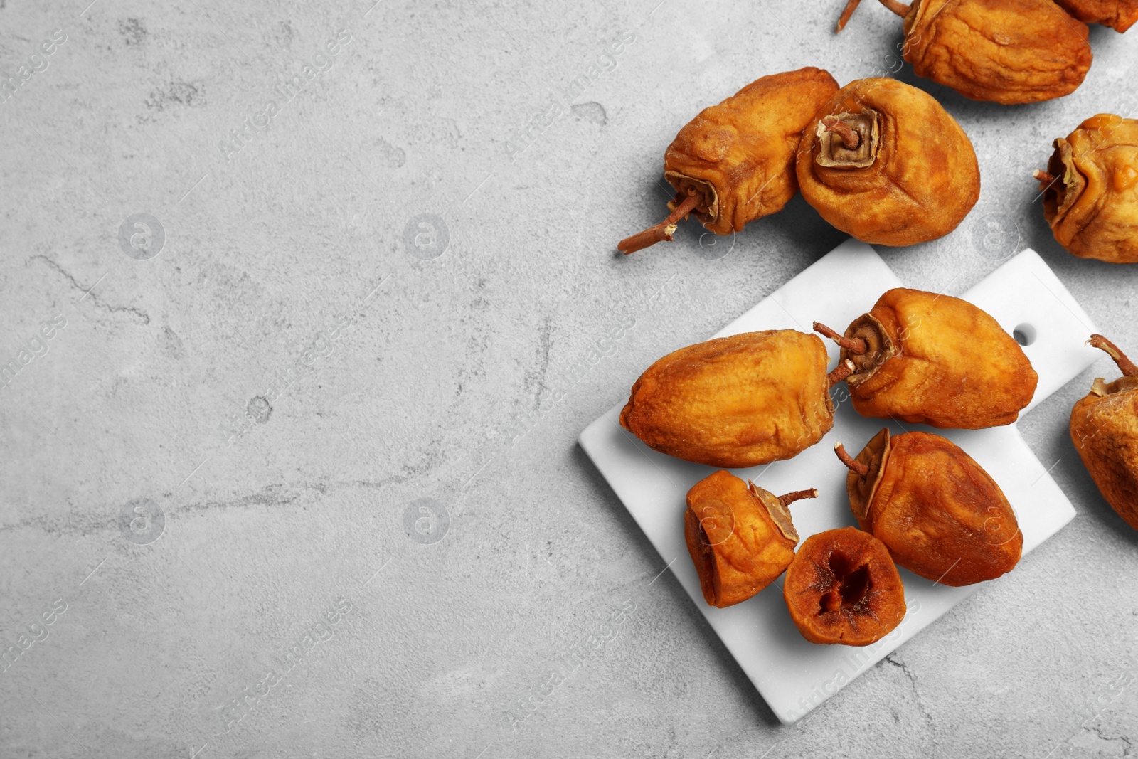 Photo of Many tasty dried persimmon fruits on light table, flat lay. Space for text