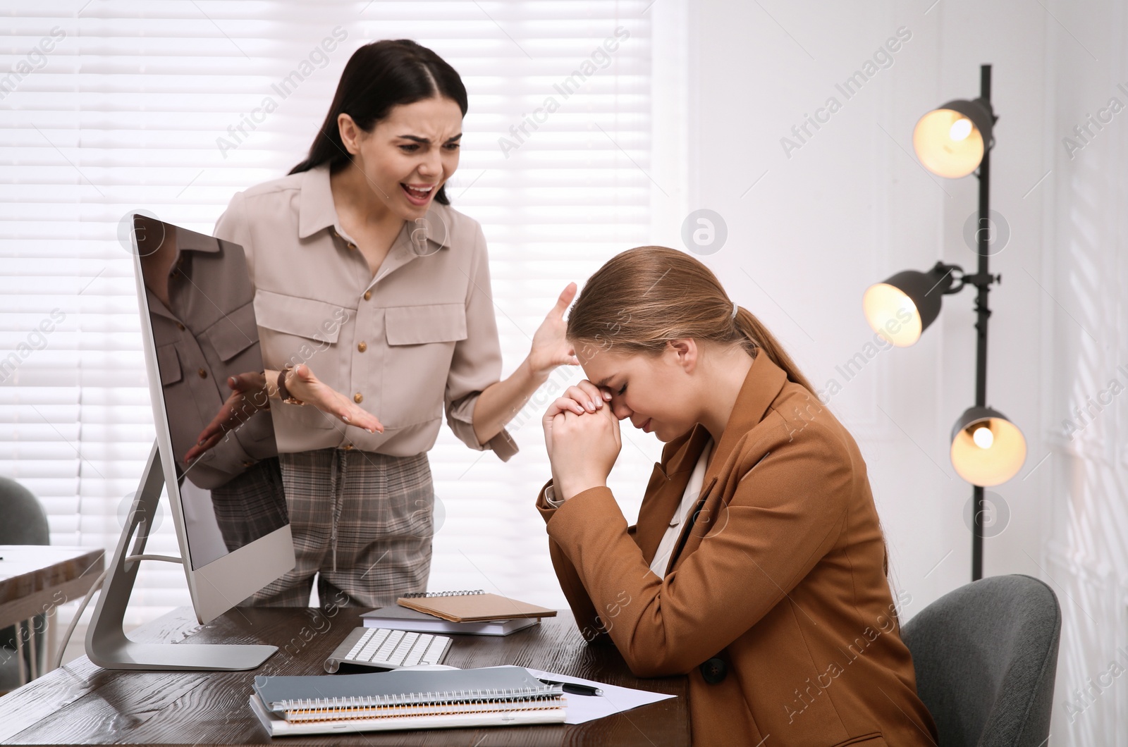 Photo of Boss screaming at employee in office. Toxic work environment