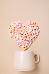 Photo of Cup and heart made of marshmallow on beige background, flat lay