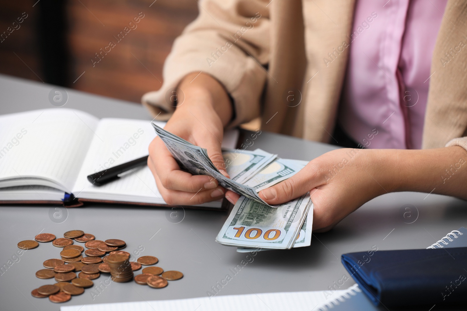 Photo of Woman counting American money at table indoors, closeup