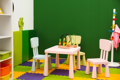 Photo of Stylish playroom interior with table and chairs