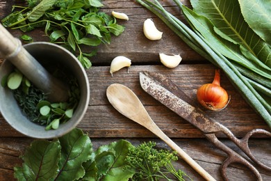Flat lay composition with different herbs, rusty scissors and spoon on wooden table