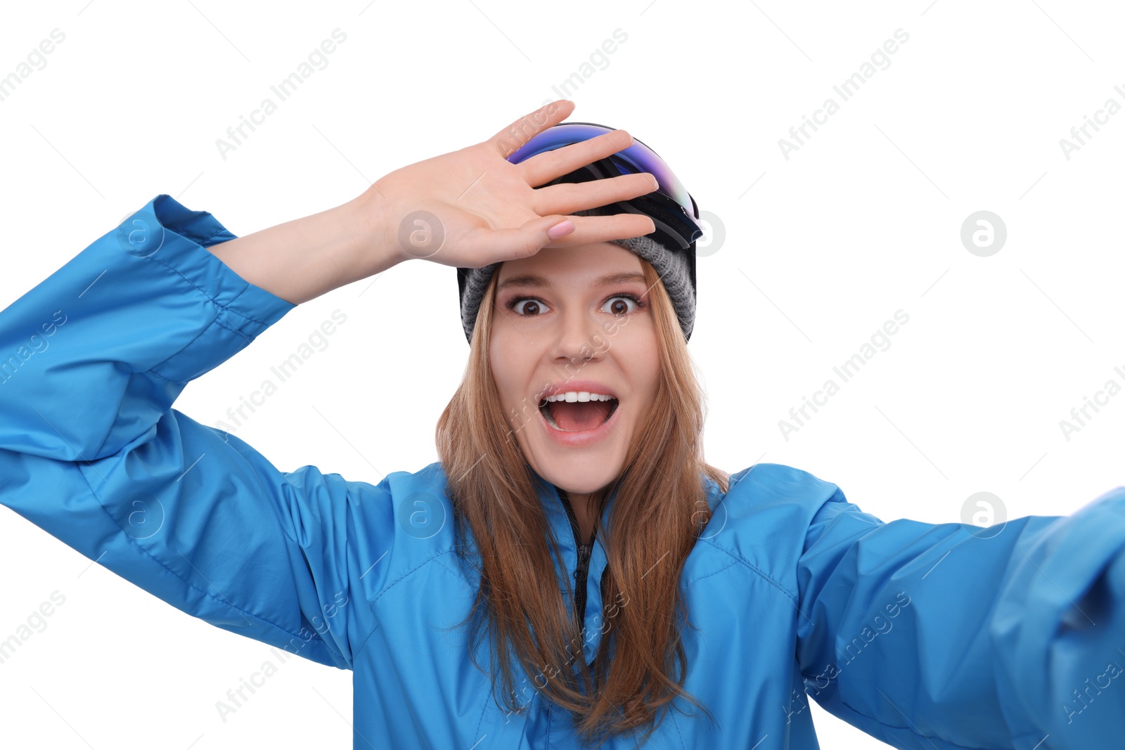 Photo of Emotional woman in ski goggles taking selfie on white background