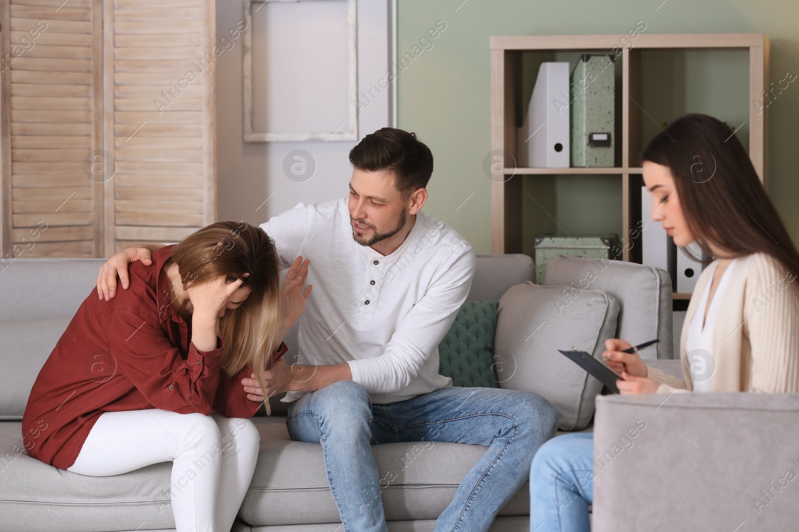 Photo of Family psychologist working with young couple in office