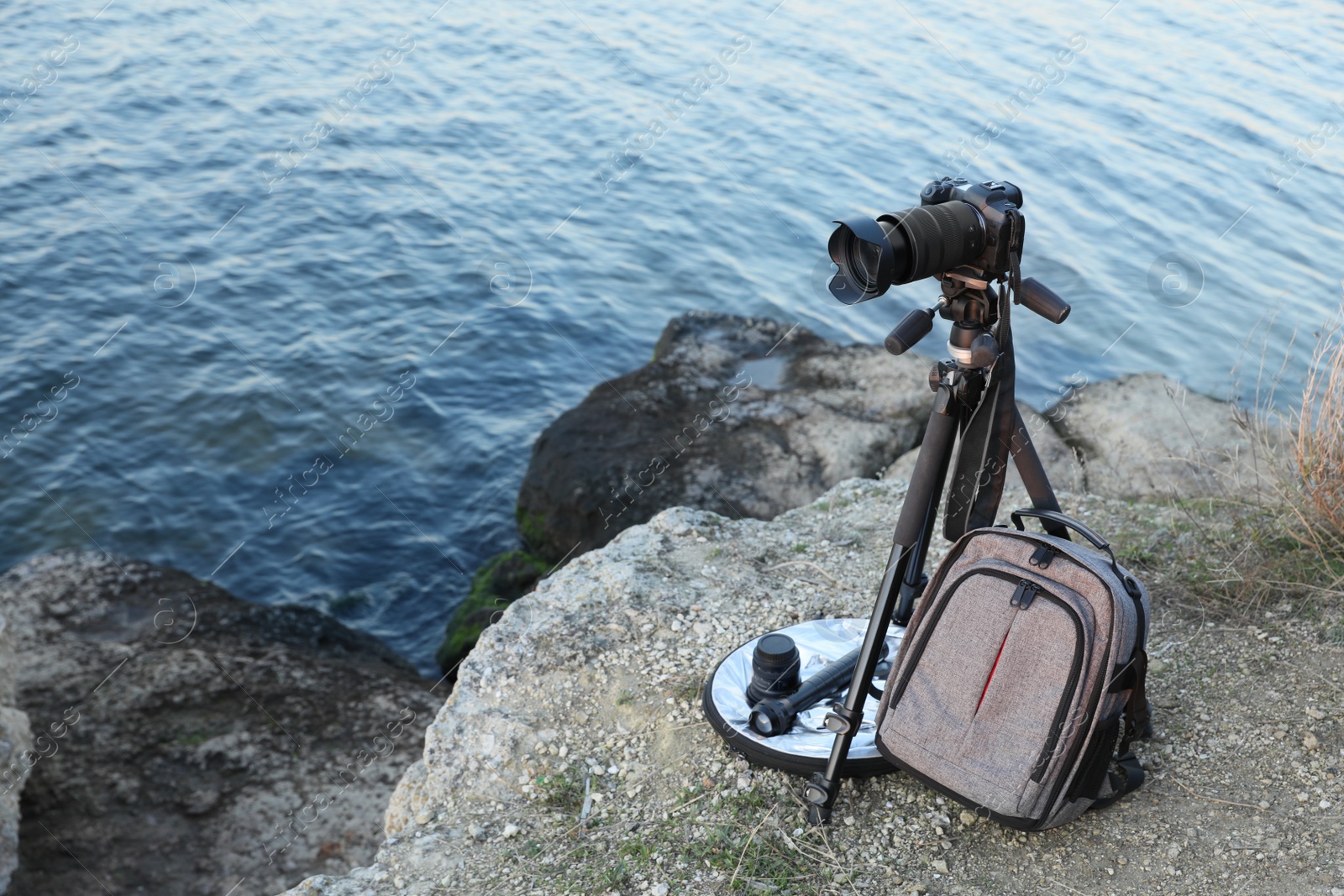 Photo of Professional photography equipment on rocky river coast