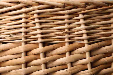 Handmade wicker basket made of natural material as background, closeup view