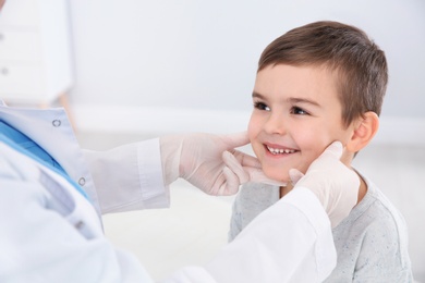 Photo of Dermatologist examining little boy's birthmark in clinic