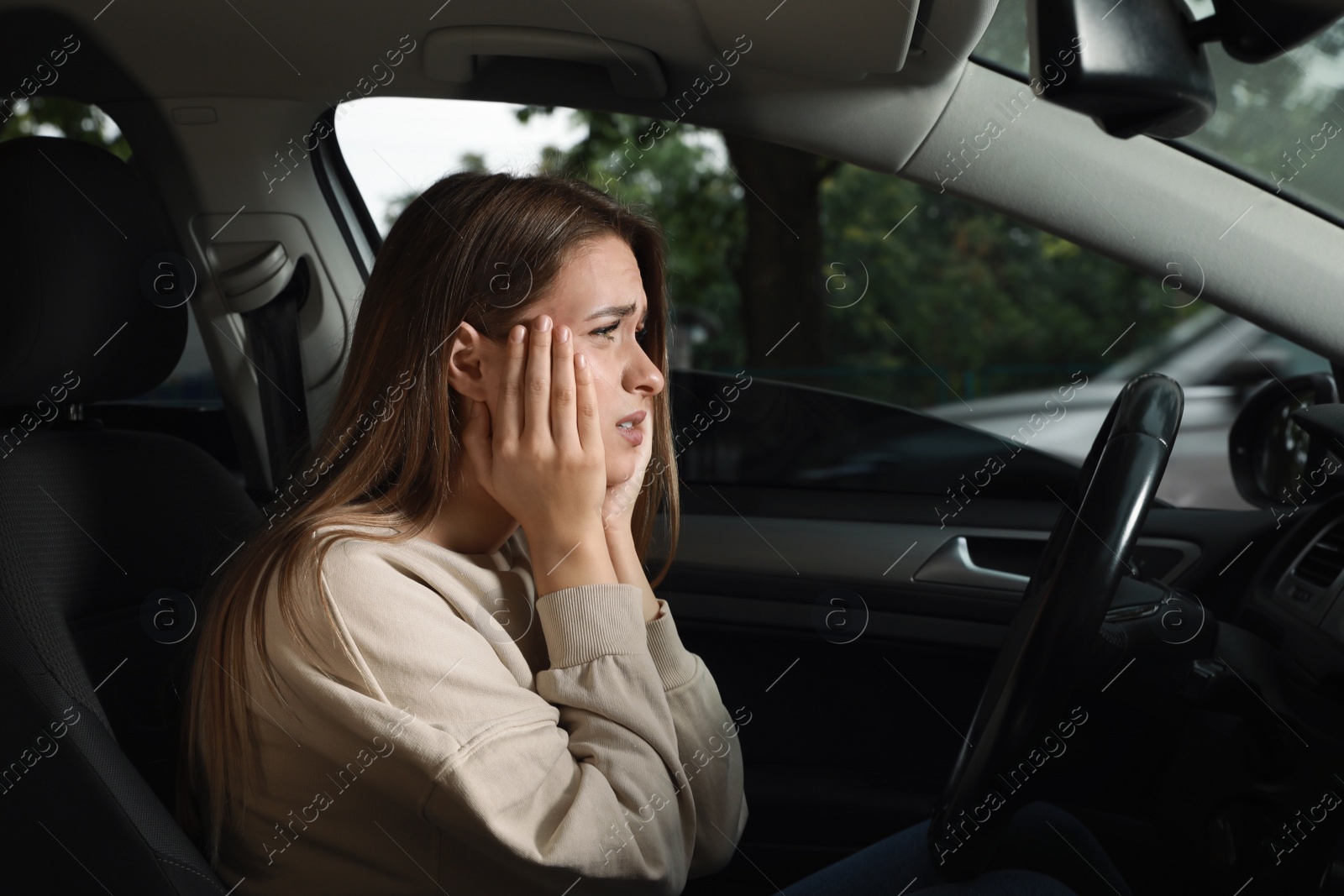 Photo of Stressed young woman in driver's seat of modern car