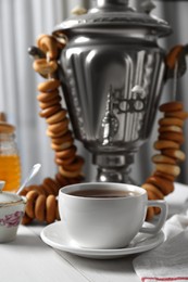 Photo of Composition with delicious ring shaped Sushki (dry bagels) and tea on white wooden table indoors