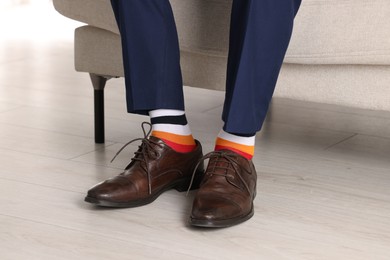 Photo of Man wearing stylish shoes and colorful socks indoors, closeup