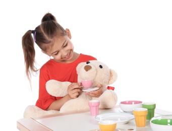 Little child playing tea party with toy on white background. Indoor entertainment