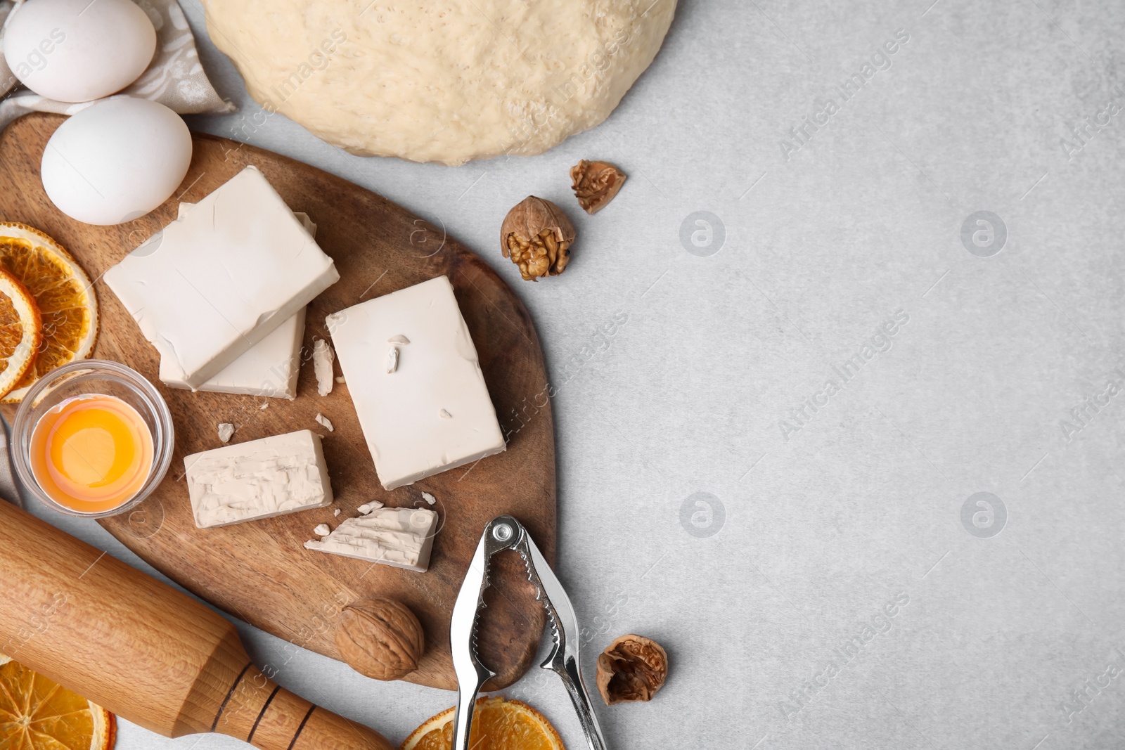 Photo of Yeast and food ingredients on light gray table, flat lay. Space for text