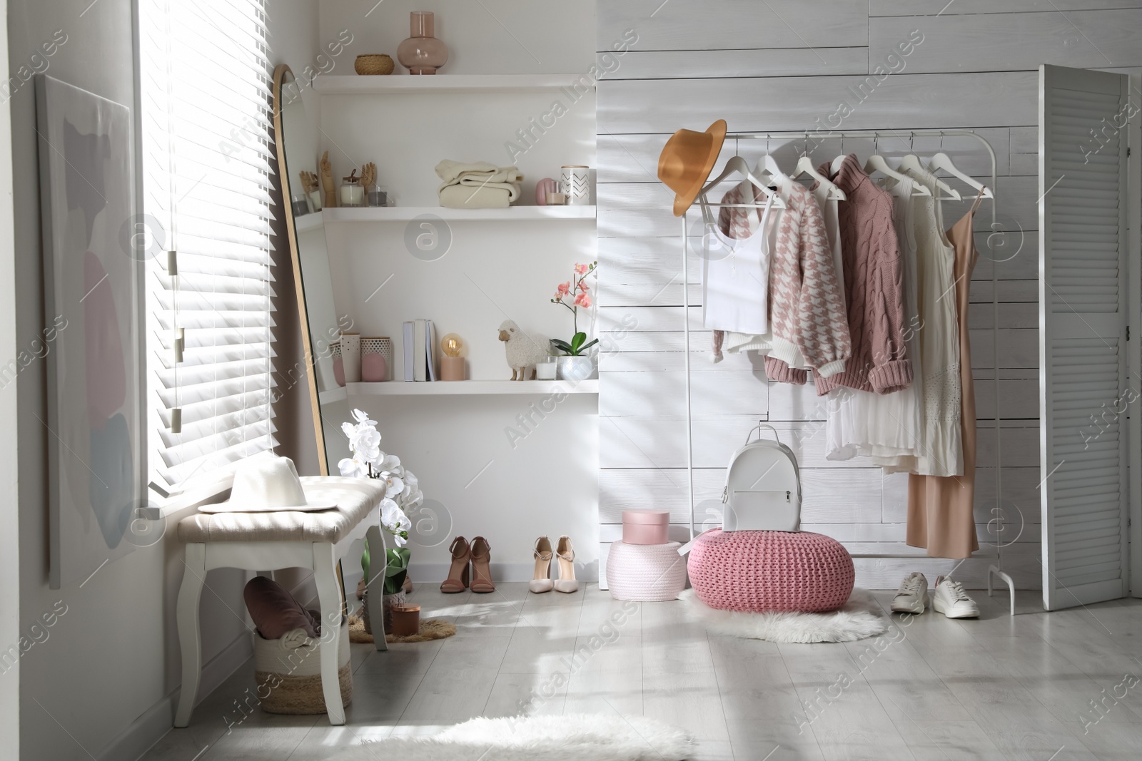 Photo of Rack with different stylish clothes, shoes and decorative elements in dressing room. Interior design