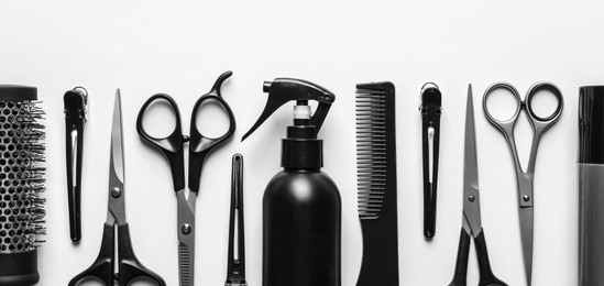 Image of Set with scissors and other hairdresser's accessories on white background, flat lay. Banner design