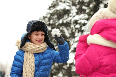 Little children playing with snow outdoors on winter day