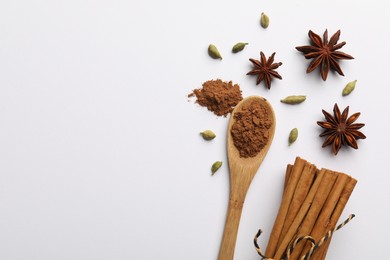 Cinnamon sticks, star anise and cardamom pods on white background, flat lay. Space for text