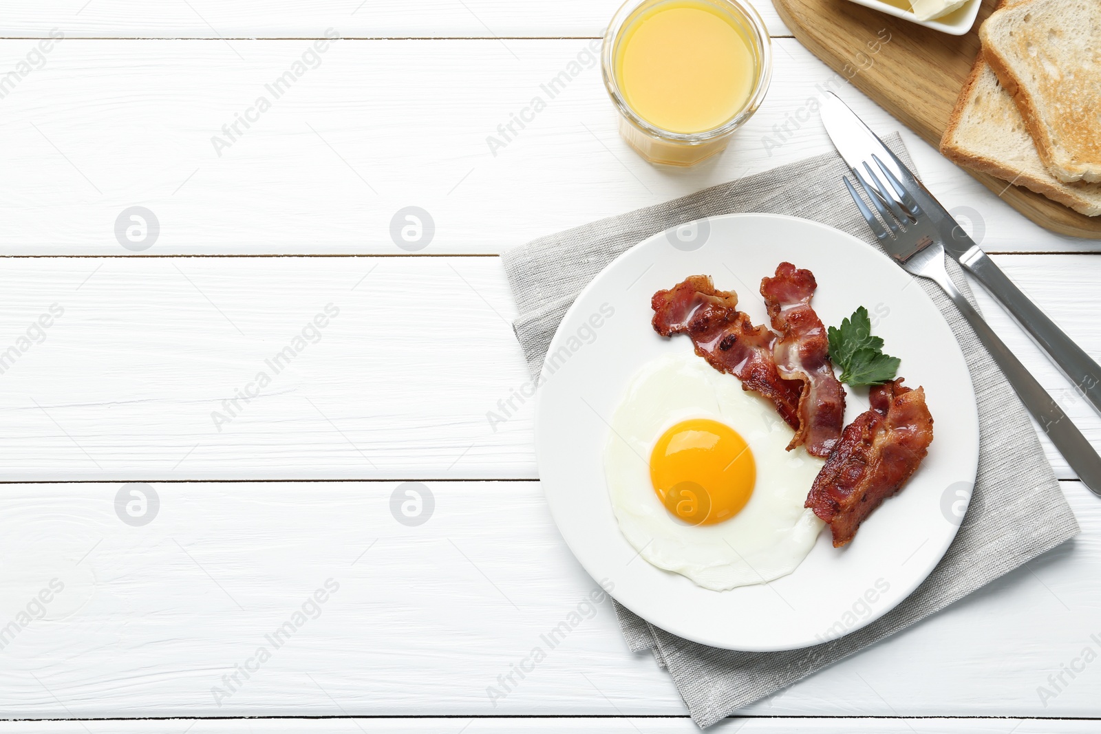 Photo of Delicious breakfast with sunny side up egg served on white wooden table, flat lay. Space for text