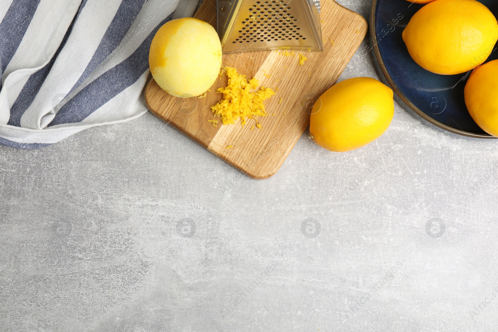 Photo of Lemon zest and fresh fruits on grey table, flat lay. Space for text