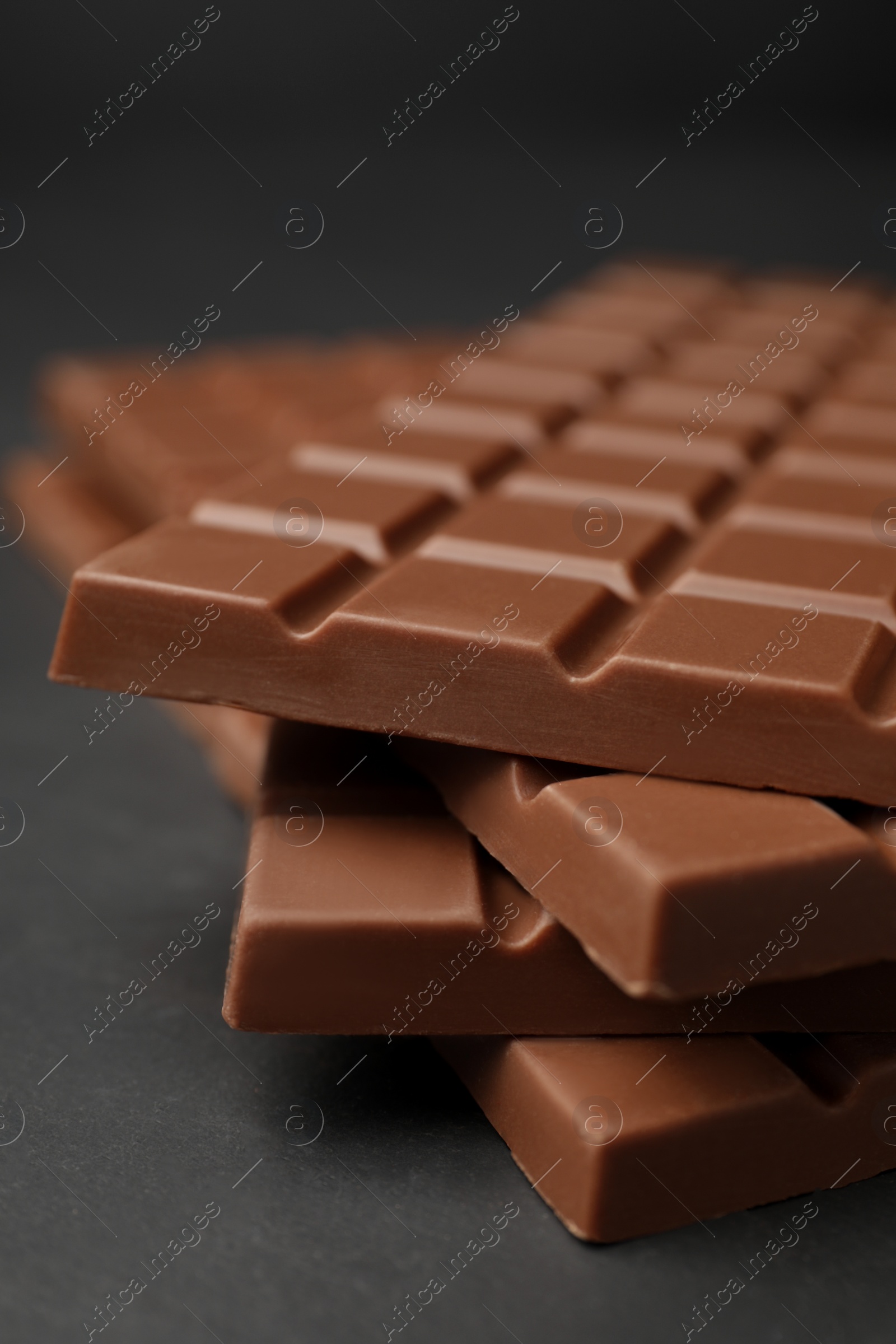 Photo of Tasty chocolate bars on grey table, closeup