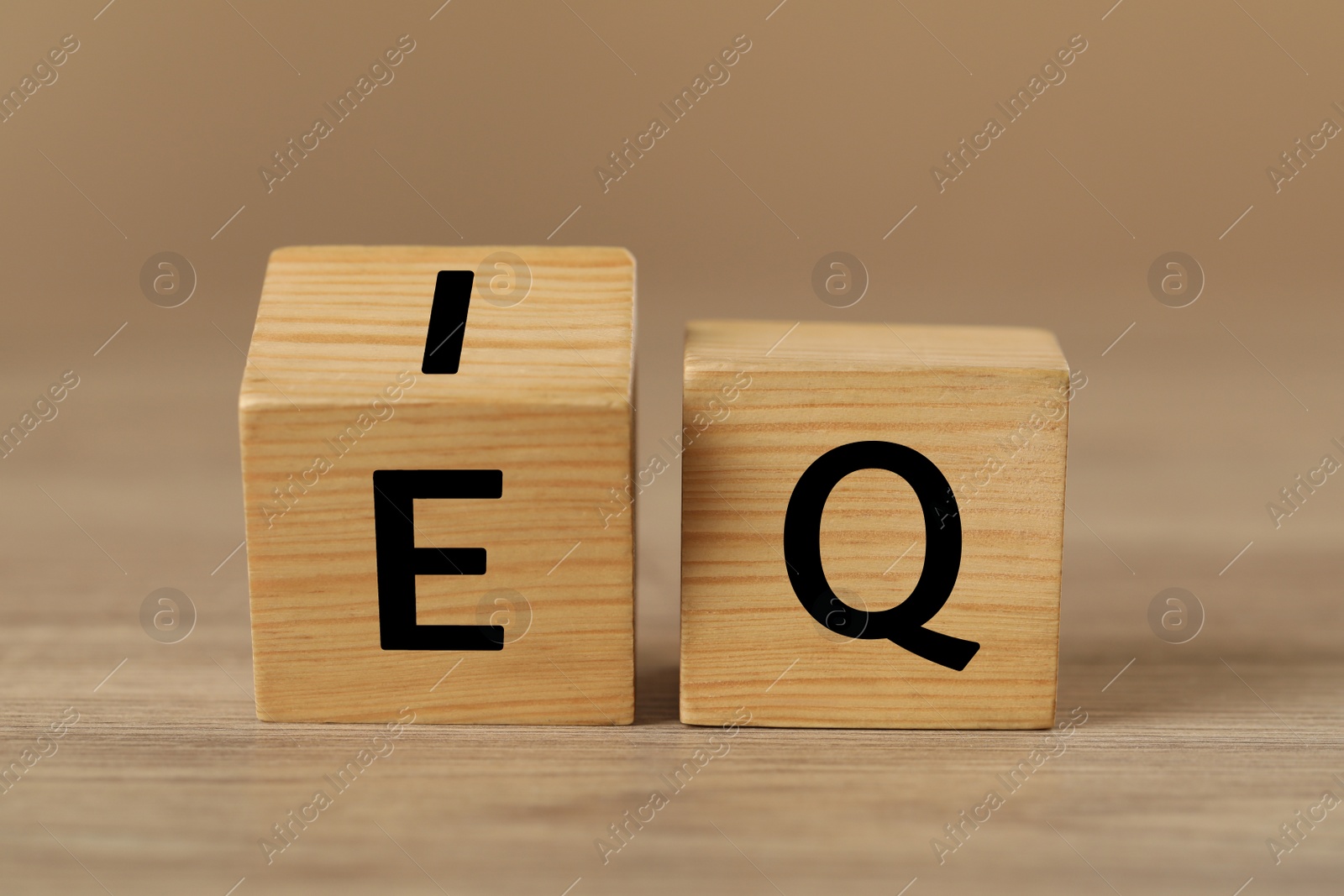 Photo of Cubes with letters E, I and Q on wooden table