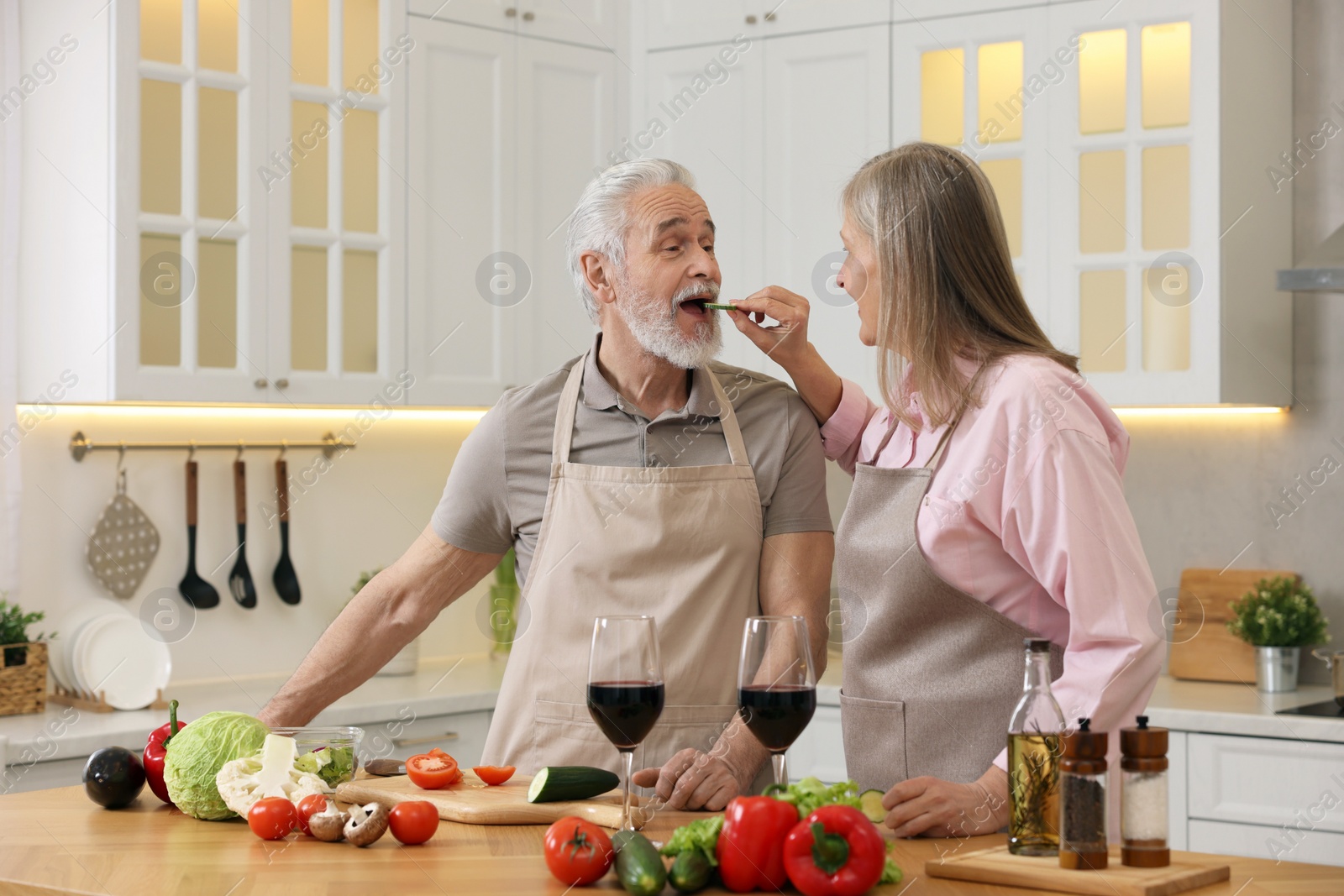 Photo of Happy senior couple cooking together in kitchen