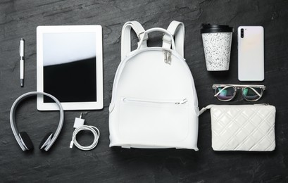 Photo of Stylish urban backpack and different items on black table, flat lay