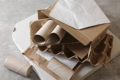 Photo of Stack of different waste paper on grey table, closeup