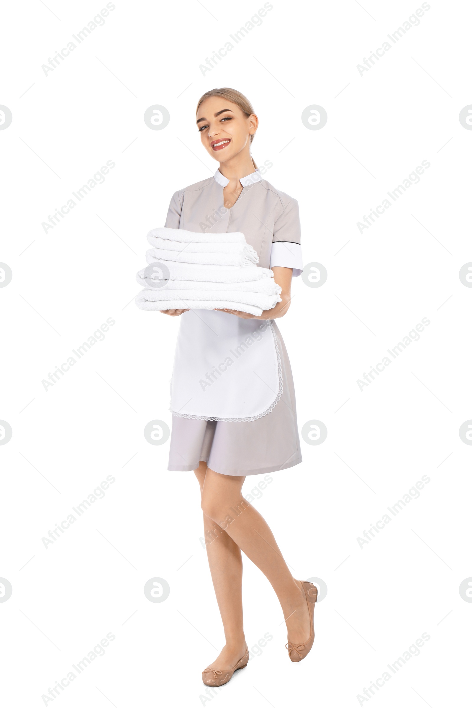 Photo of Young chambermaid with stack of clean towels on white background