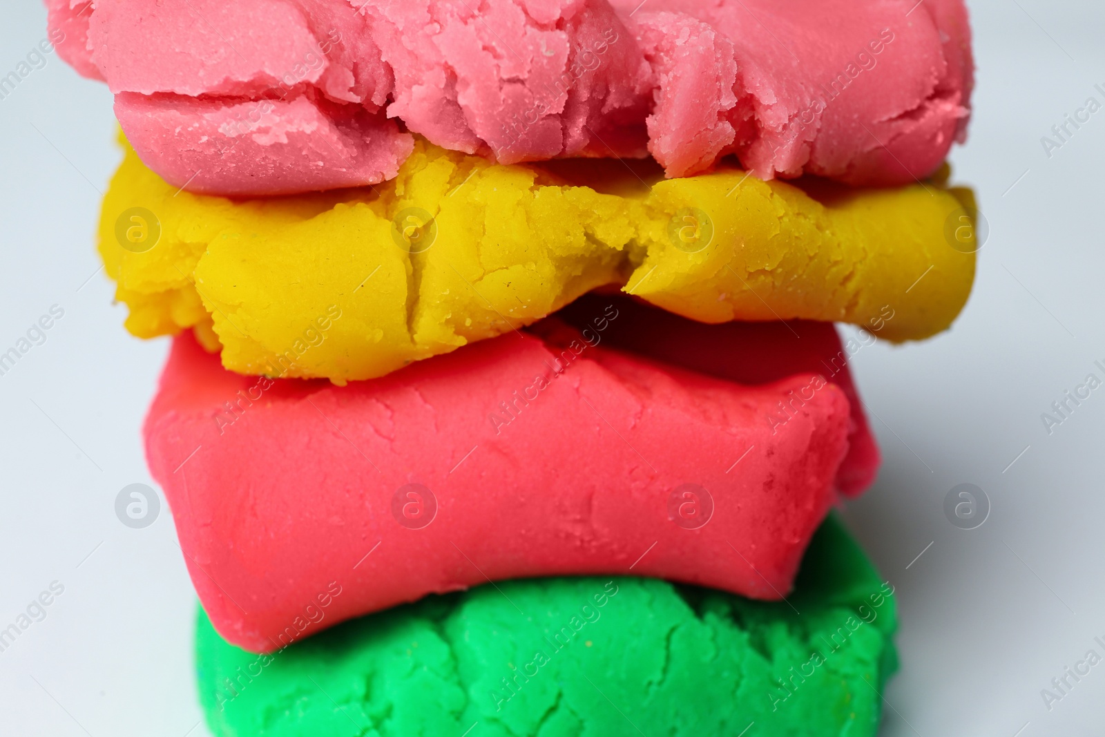 Photo of Different colorful play dough on white background, closeup