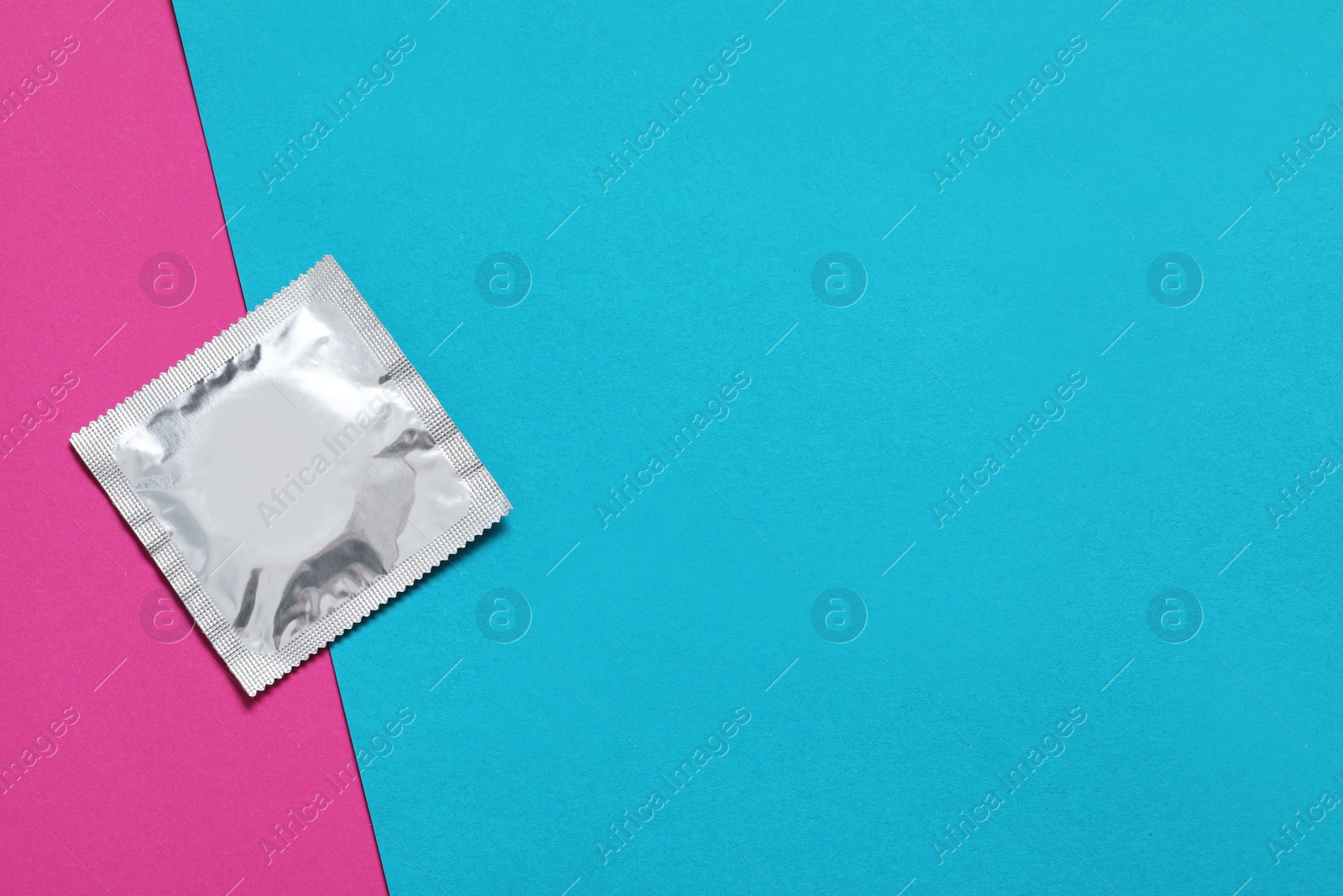 Photo of Condom package on color background, top view and space for text. Safe sex