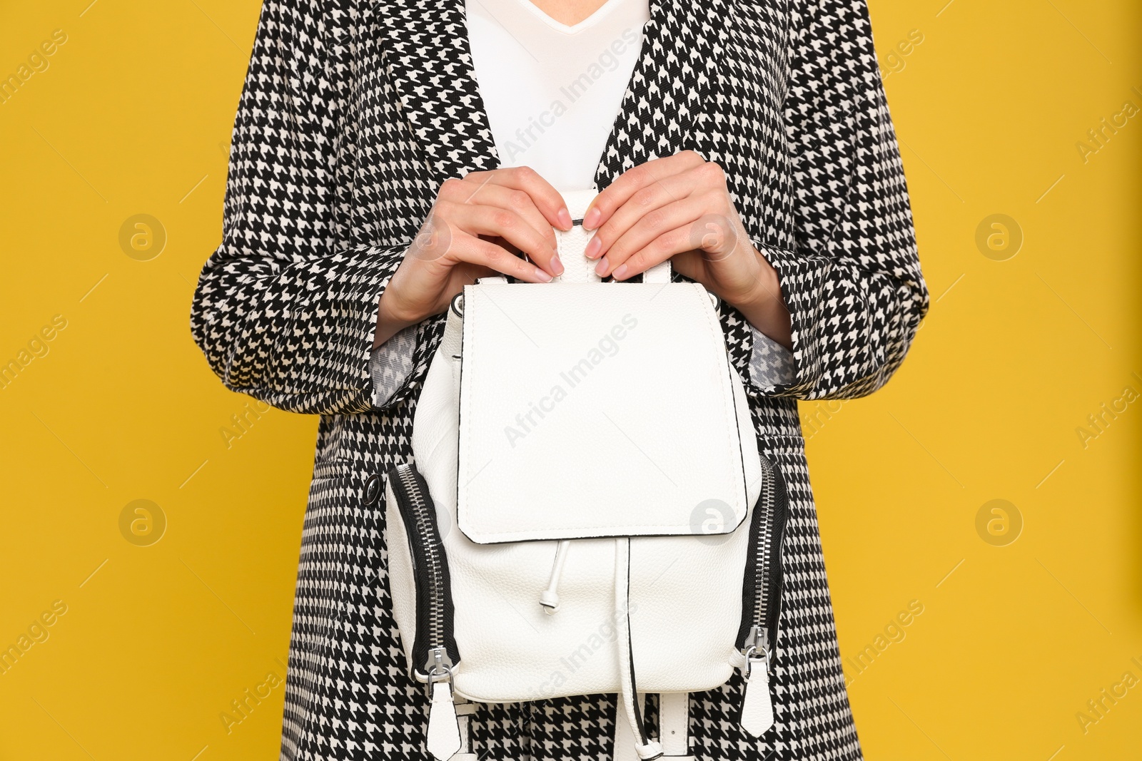 Photo of Young woman with stylish bag on yellow background, closeup