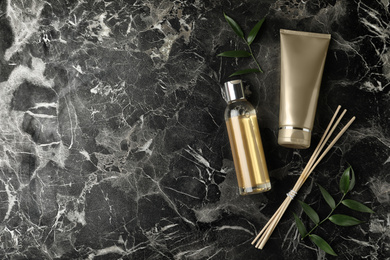 Flat lay composition with cosmetic products on black marble table. Space for text