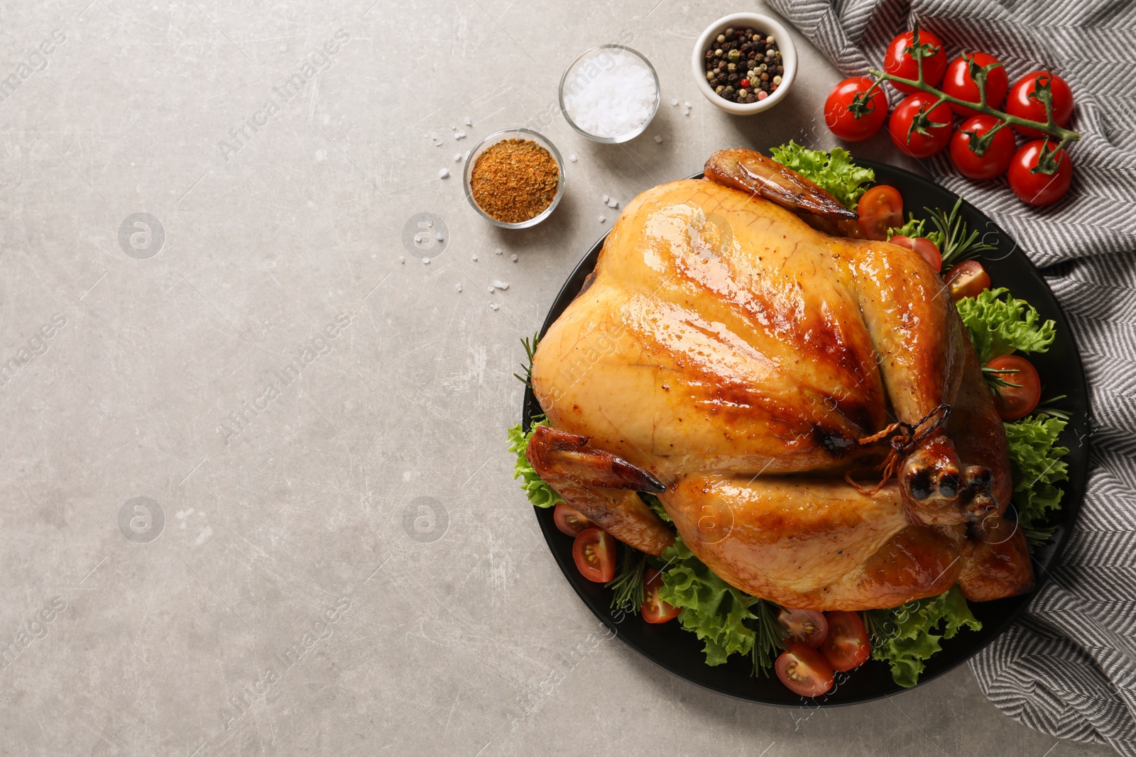 Photo of Platter of cooked turkey with garnish and spices on grey background, flat lay. Space for text