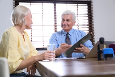 Photo of Senior notary working with client in office