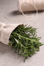 Photo of Sack with fresh rosemary on light grey table, closeup