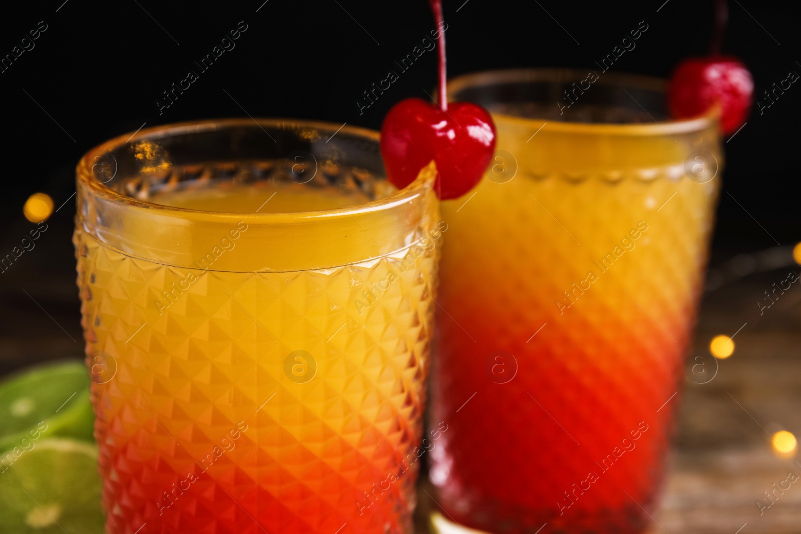 Photo of Fresh alcoholic Tequila Sunrise cocktails on wooden table, closeup