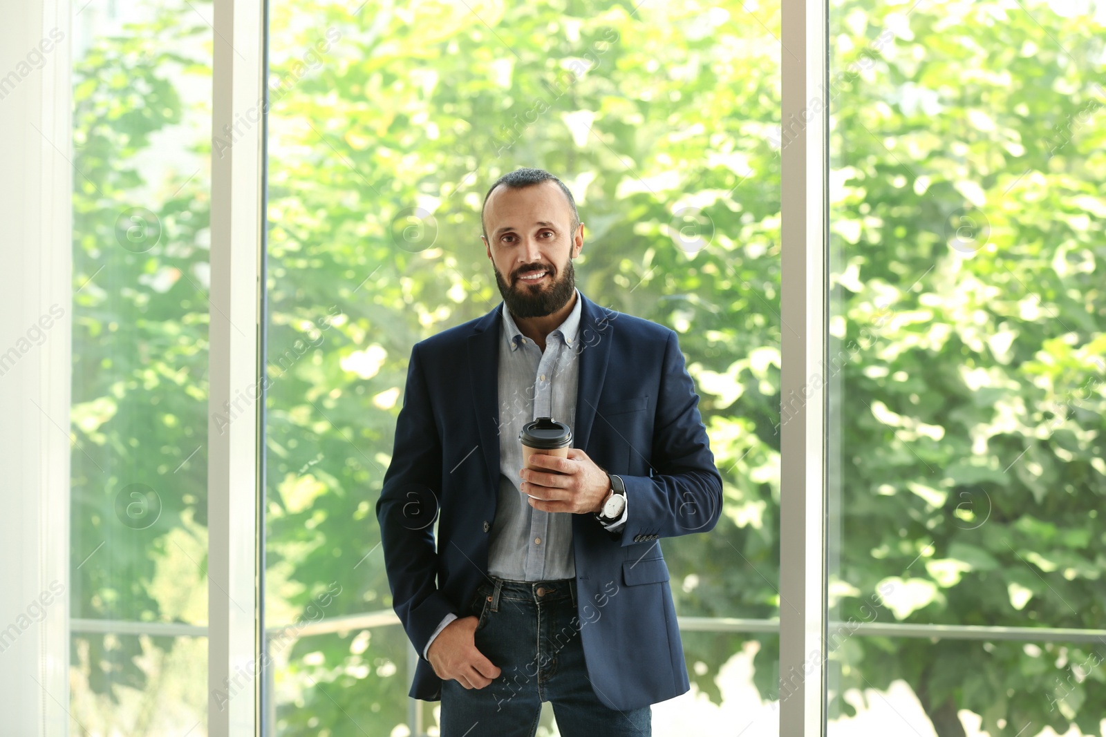 Photo of Portrait of handsome mature man in elegant suit with coffee near window