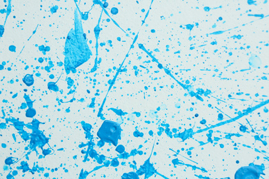 Photo of Blue paint splashes on white canvas as background. Art and creativity