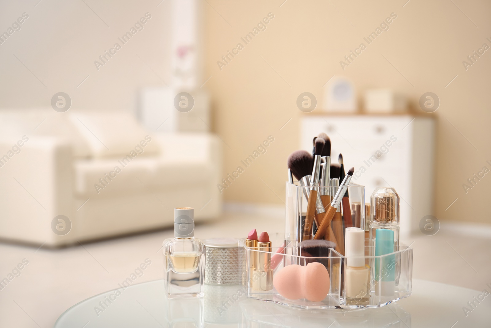 Photo of Makeup cosmetic products with tools in organizer on dressing table. Space for text