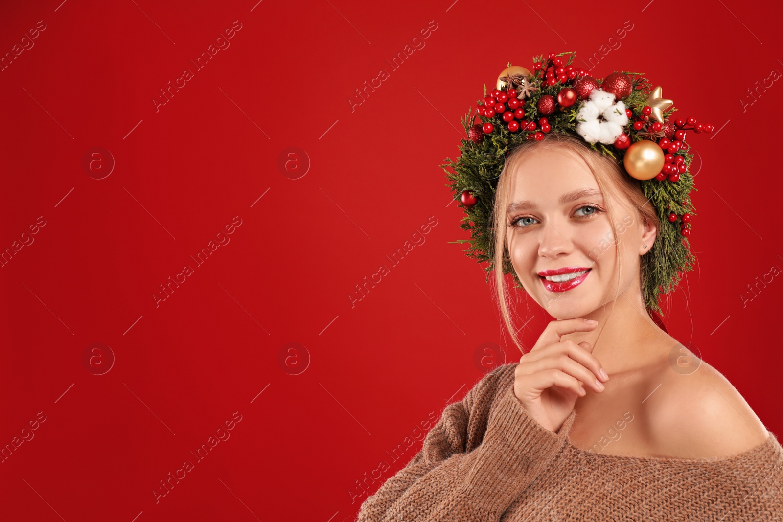 Photo of Beautiful young woman wearing Christmas wreath on red background. Space for text