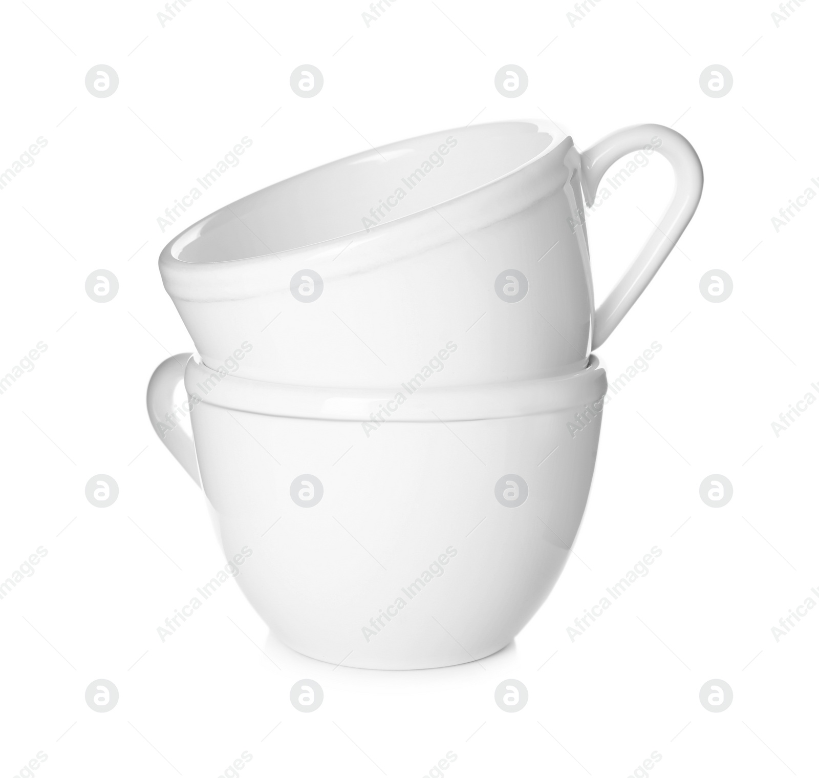 Photo of Clean empty ceramic cups isolated on white