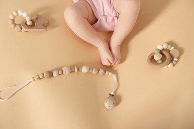 Photo of Cute baby and rattle toys on beige background, top view