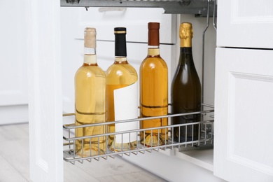 Photo of Open drawer with wine bottles in kitchen
