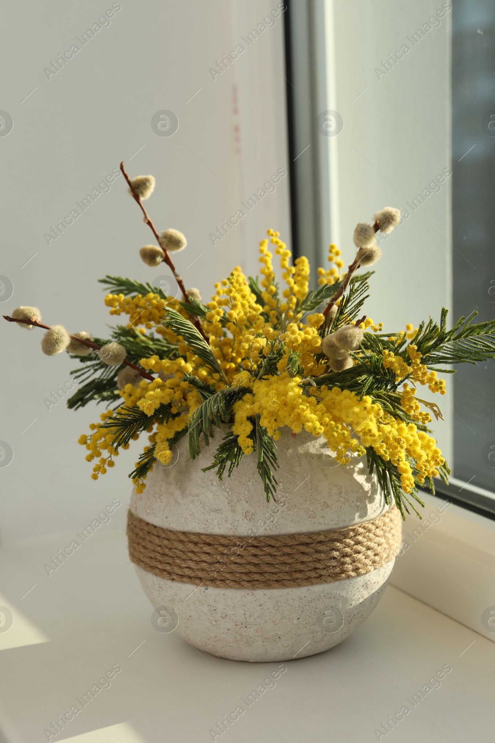 Photo of Beautiful mimosa flowers in vase on window sill indoors